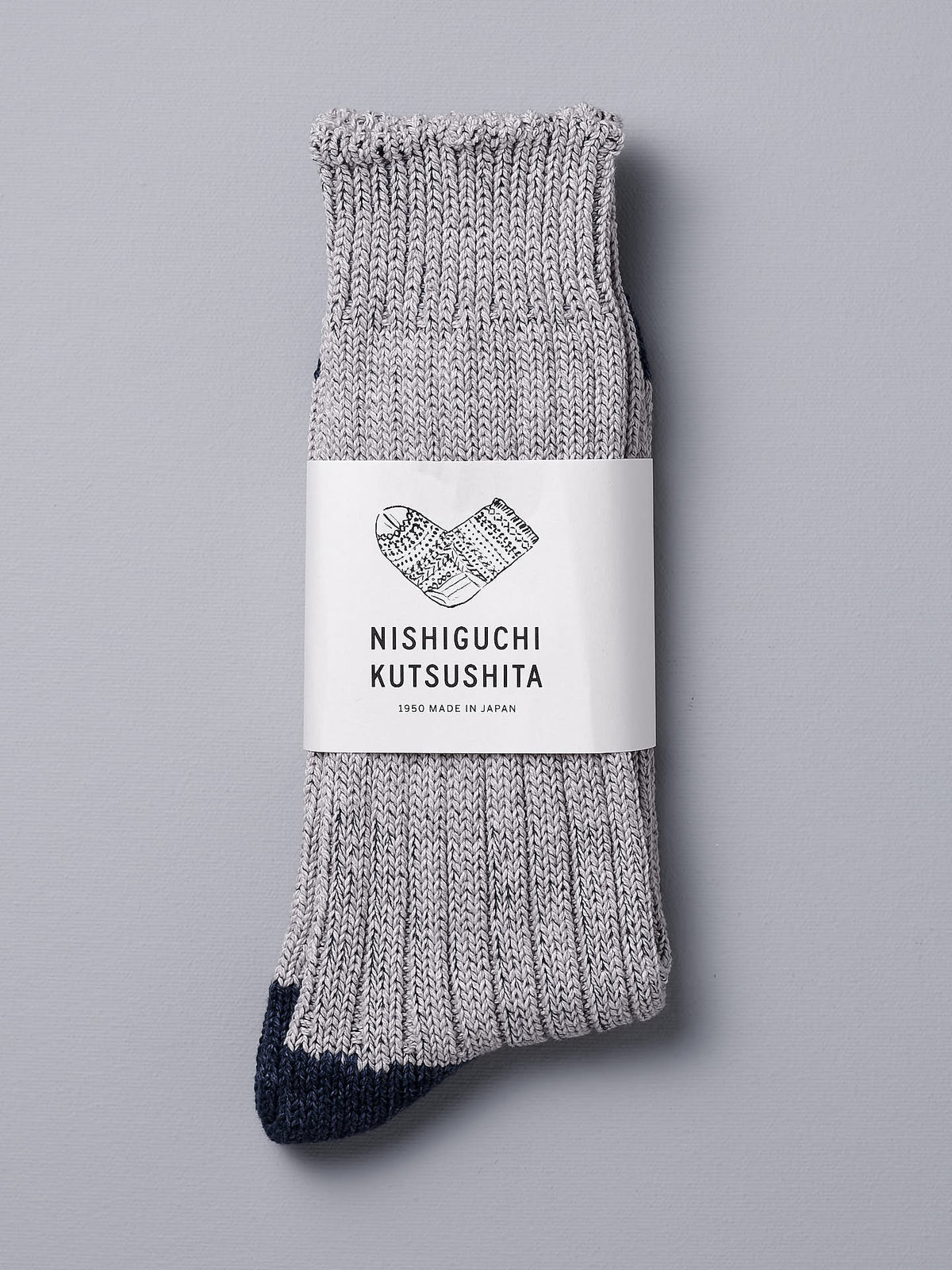 A pair of Boston Slab Socks – Grey Denim with a Nishiguchi Kutsushita label on them.