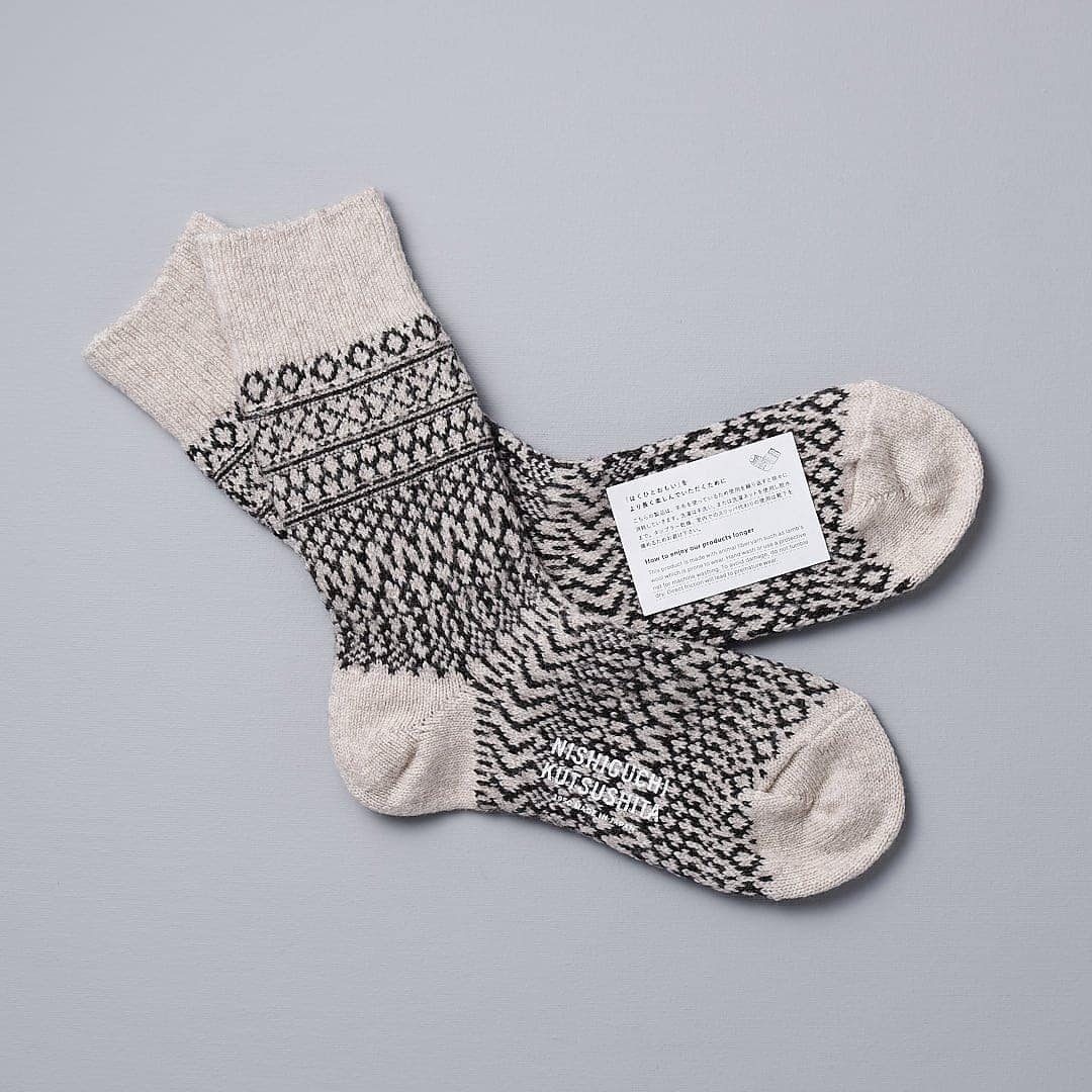 A pair of Oslo Wool Jacquard Socks – Oatmeal with a Nishiguchi Kutsushita label on them.