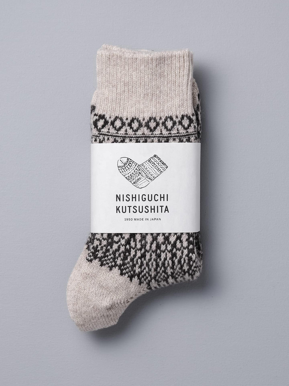A pair of Nishiguchi Kutsushita Oslo Wool Jacquard Socks – Oatmeal with a black and white pattern.