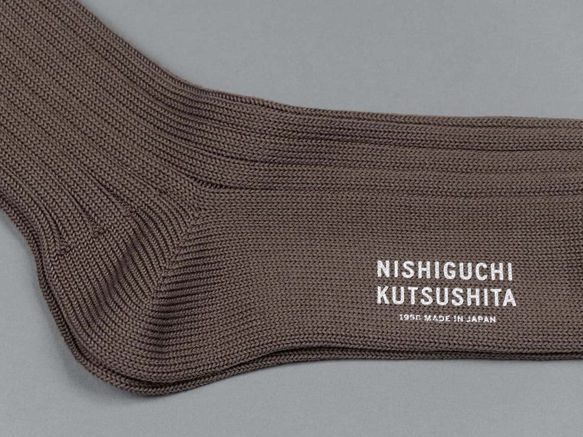 A Praha Cotton Socks - Chocolate Milk by Nishiguchi Kutsushita with a white logo on it.