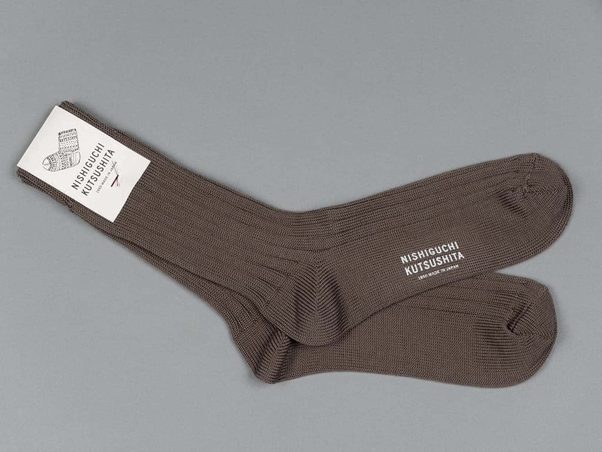 A pair of Praha Cotton Socks in the flavor of Chocolate Milk with a label on them, made by Nishiguchi Kutsushita.