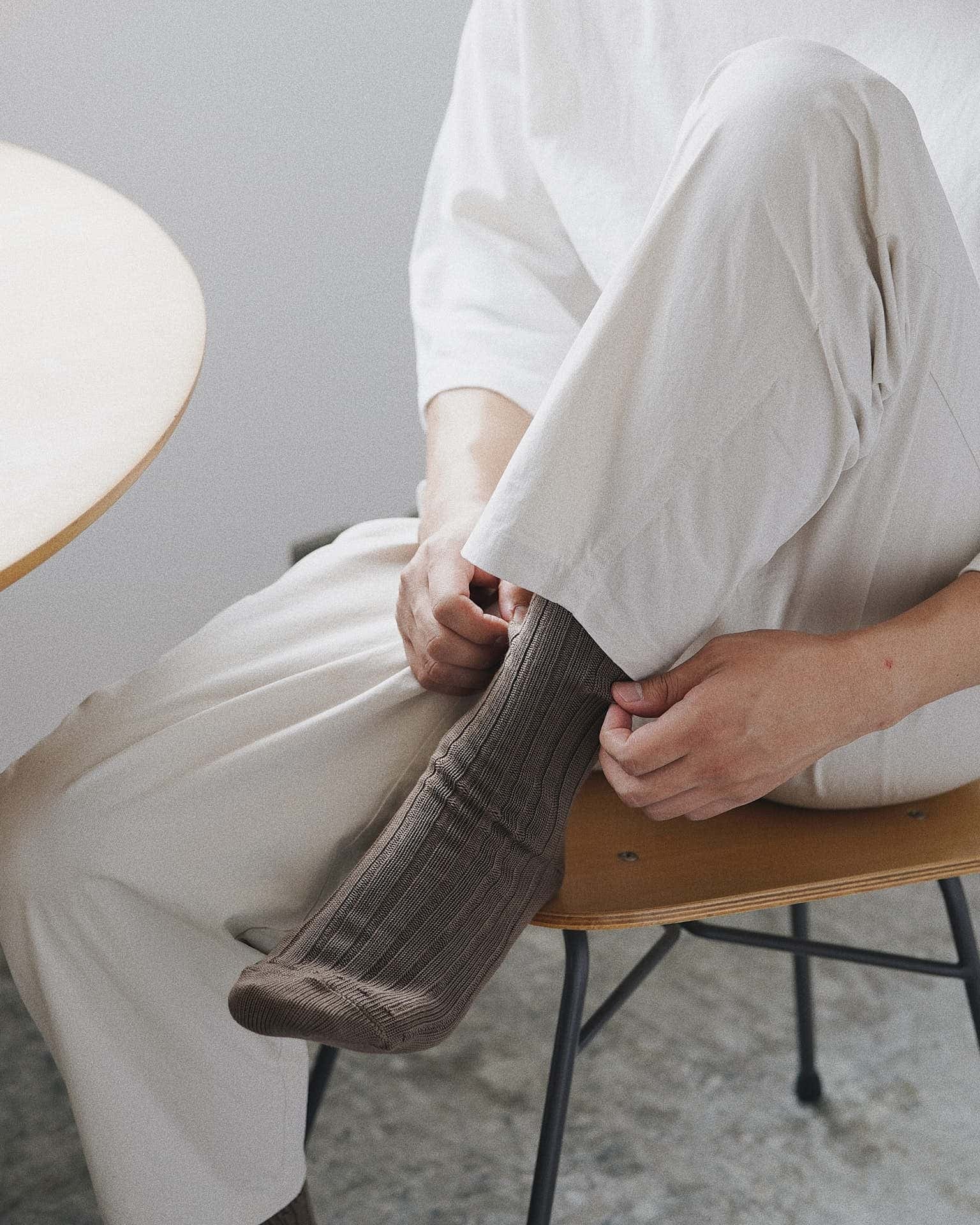 A pair of Praha Cotton Socks – Chocolate Milk by Nishiguchi Kutsushita laid flat on a light grey background, perfect to complement both men's and women's shoes. Check the size guide for the best fit across EUR and US sizes.