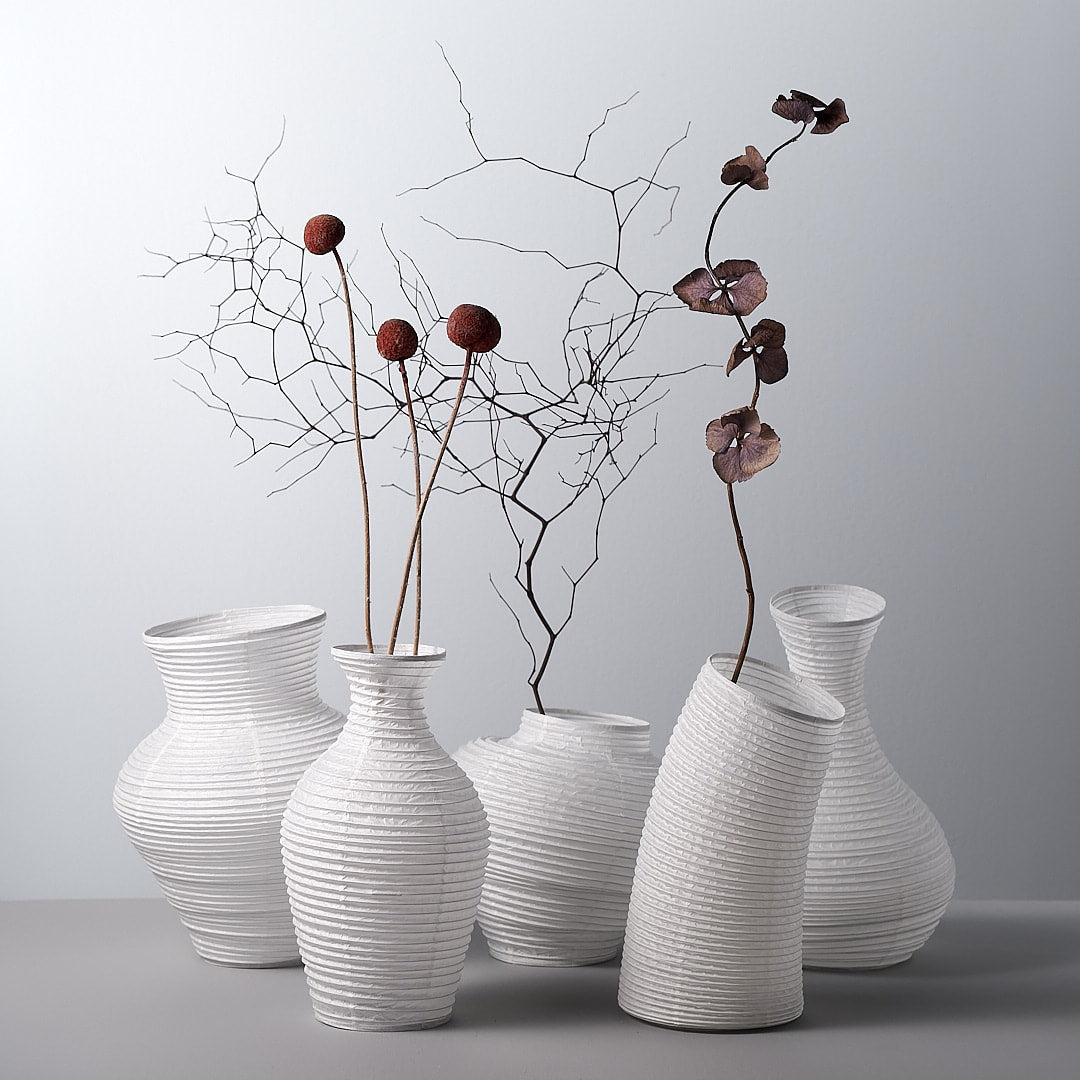 A group of Nobi-tsutsu Paper Vases – №2 by Hayashi Kougei with branches in them.