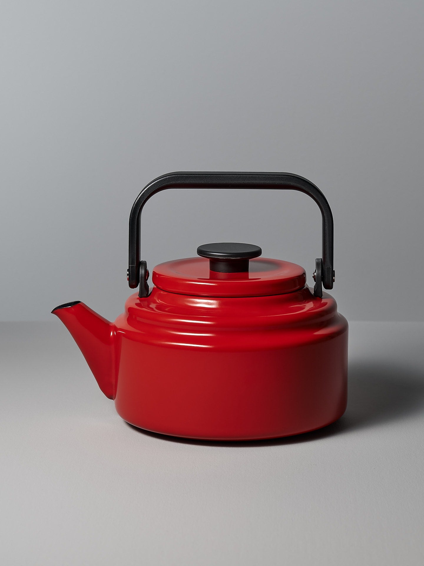 An Amu Stove-top Kettle - Red by Noda Horo on a grey background.