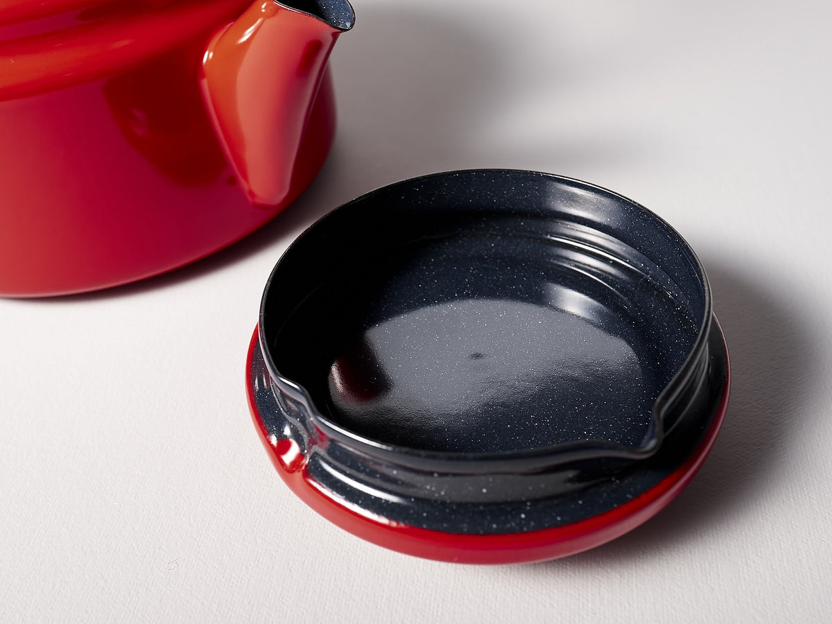 A Noda Horo Amu Stove-top Kettle – Red next to a black bowl.