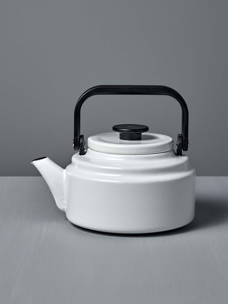 A white Amu Stove-top Kettle with a black handle on a grey background. (Brand: Noda Horo)