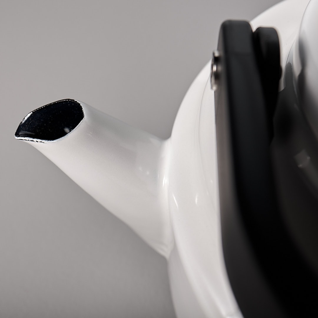 A close up of a Noda Horo Amu Stove-top Kettle – White with a black handle.