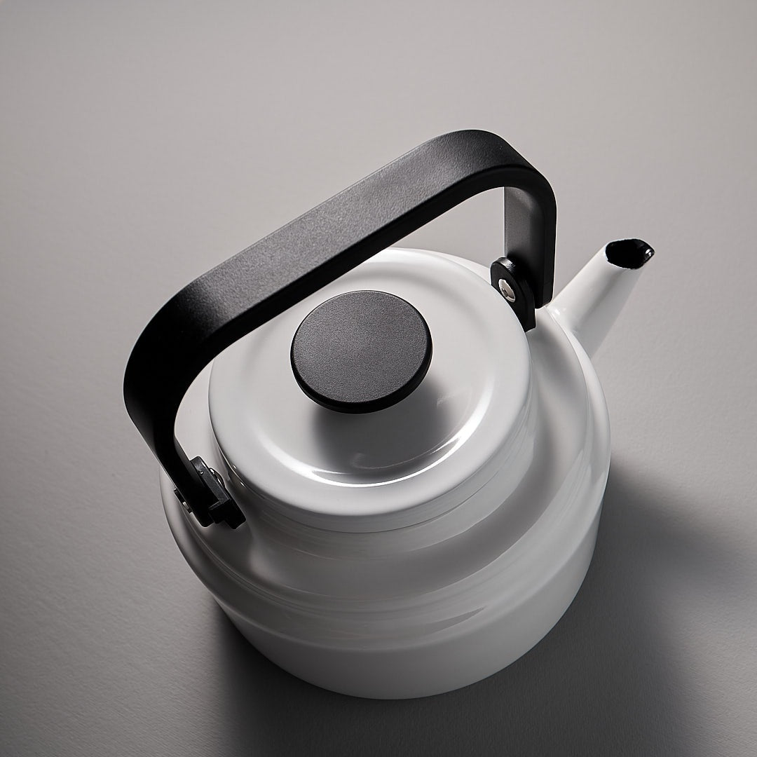 A Amu Stove-top Kettle – White with a black handle.