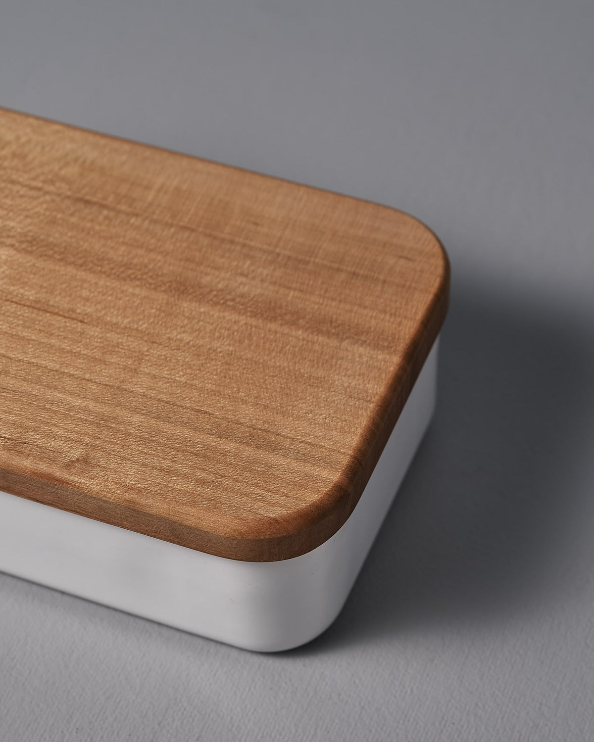 A Noda Horo Enamel Butter Case – 200𝚐 with a lid on a grey surface.
