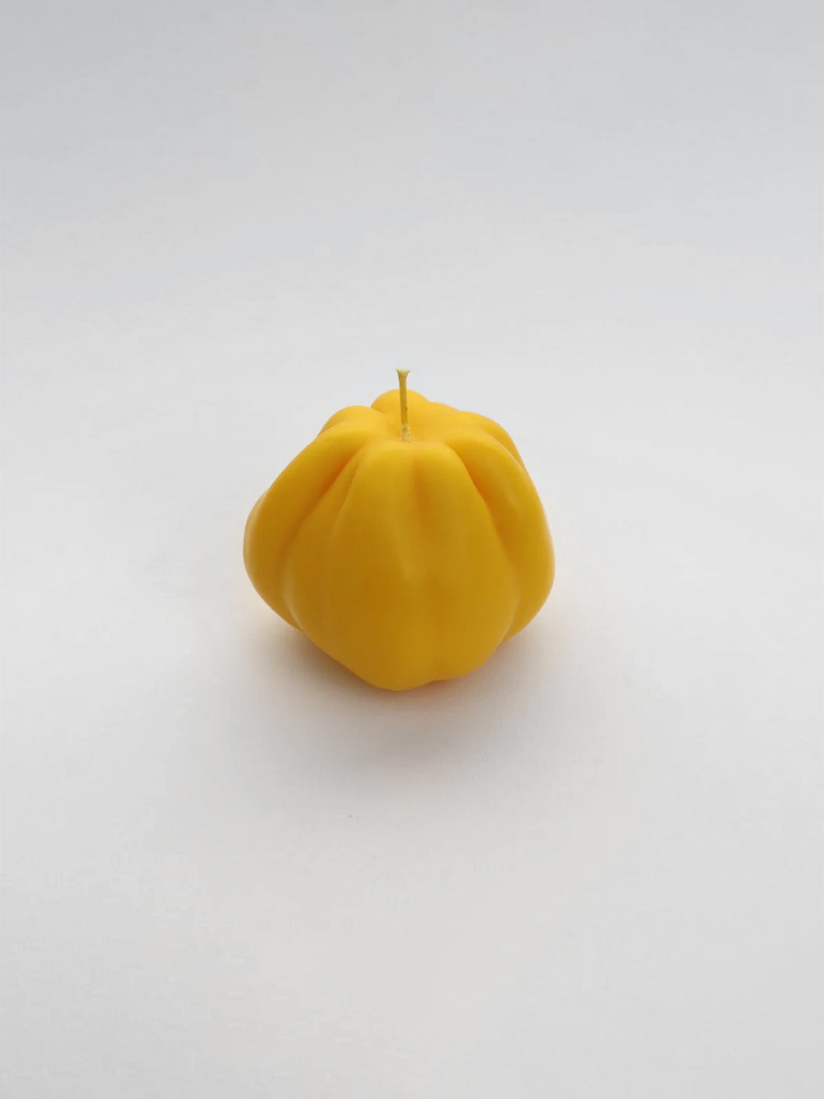 A Yellow Heirloom Tomato Candle – Small by Nonna&#39;s Grocer on a white surface.