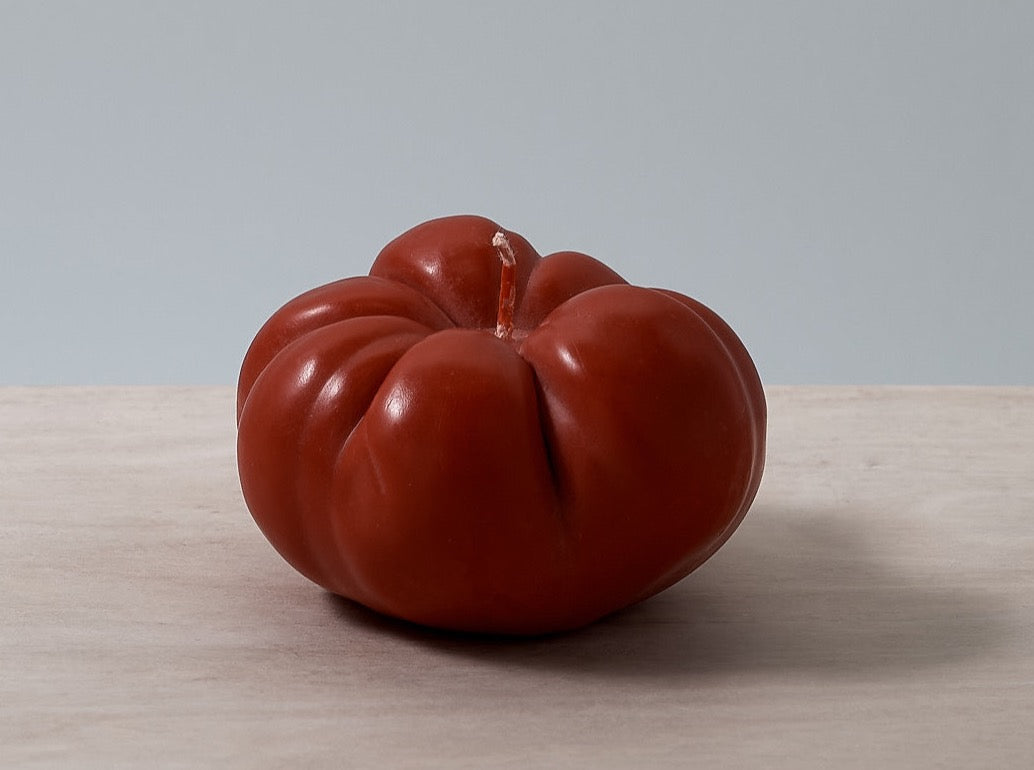 A Nonna&#39;s Grocer Tomato Candle – Large sitting on a wooden table.