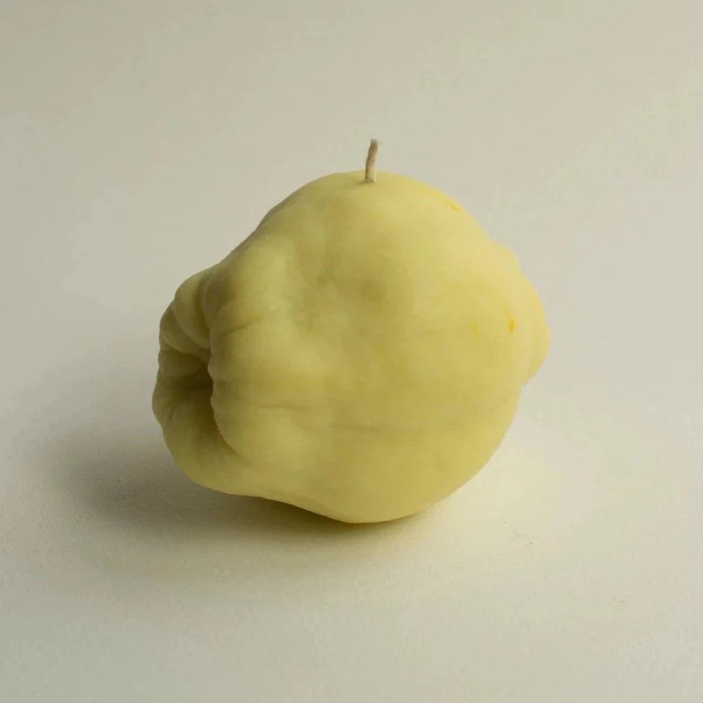 A Quince Candle from Nonna&#39;s Grocer on a white surface.