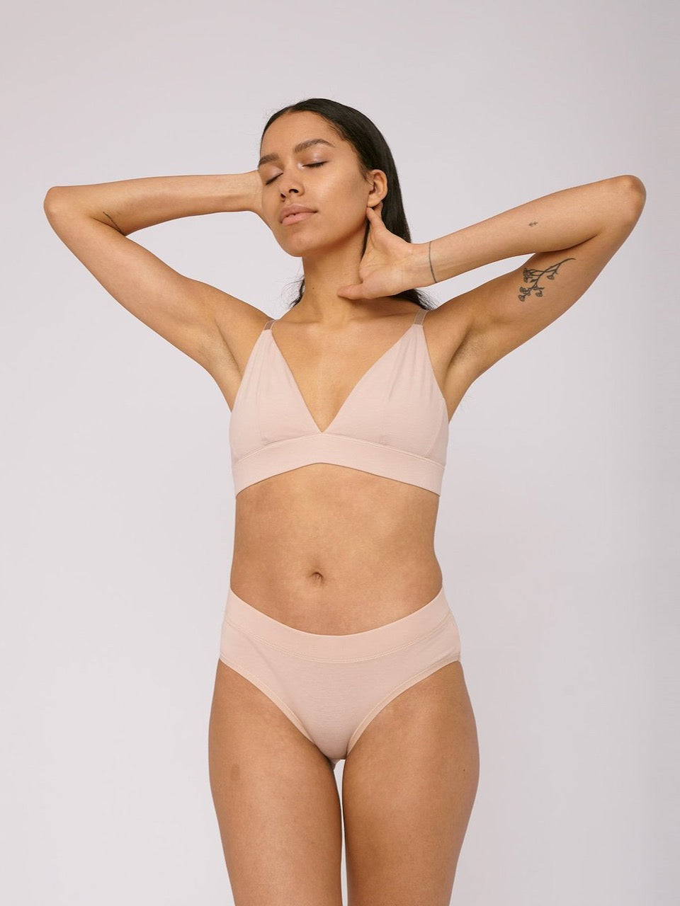 The model is wearing a Organic Basics Bikini Briefs ⋅ organic cotton (2-pack) - Rose Nude.