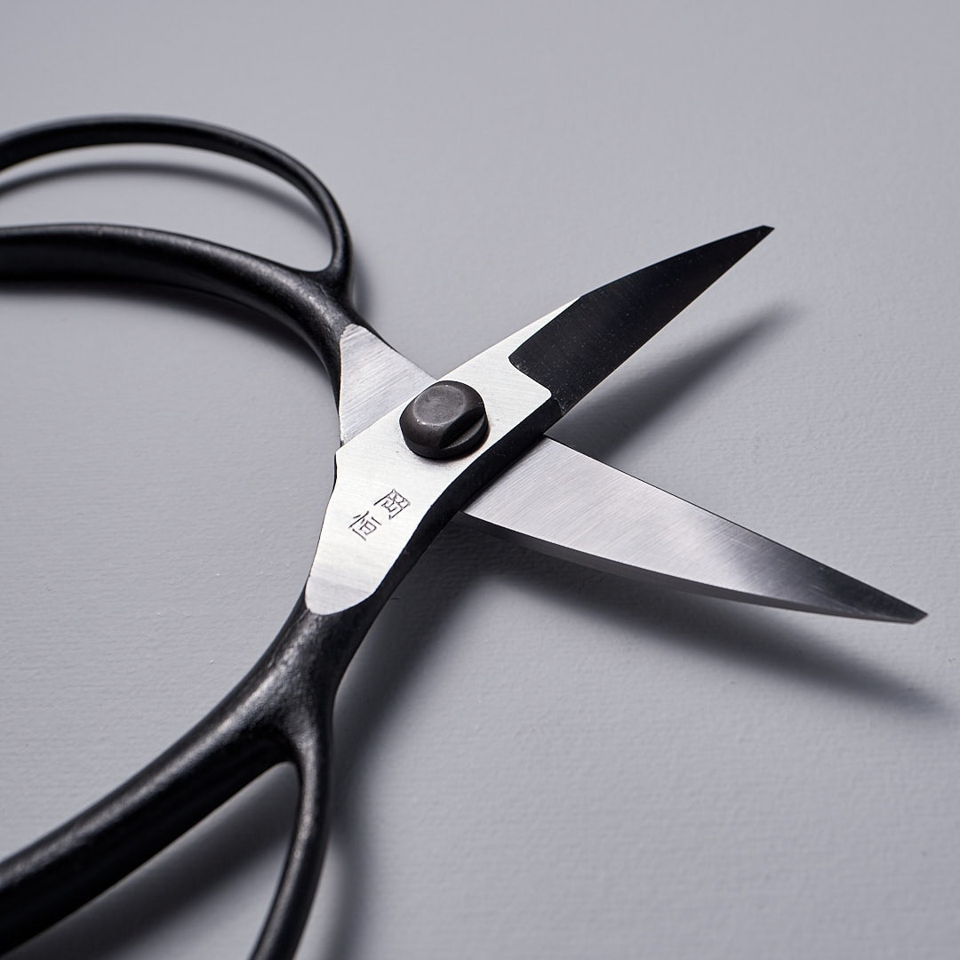 A pair of Okatsune Garden Scissors №221 – Small on a gray surface.