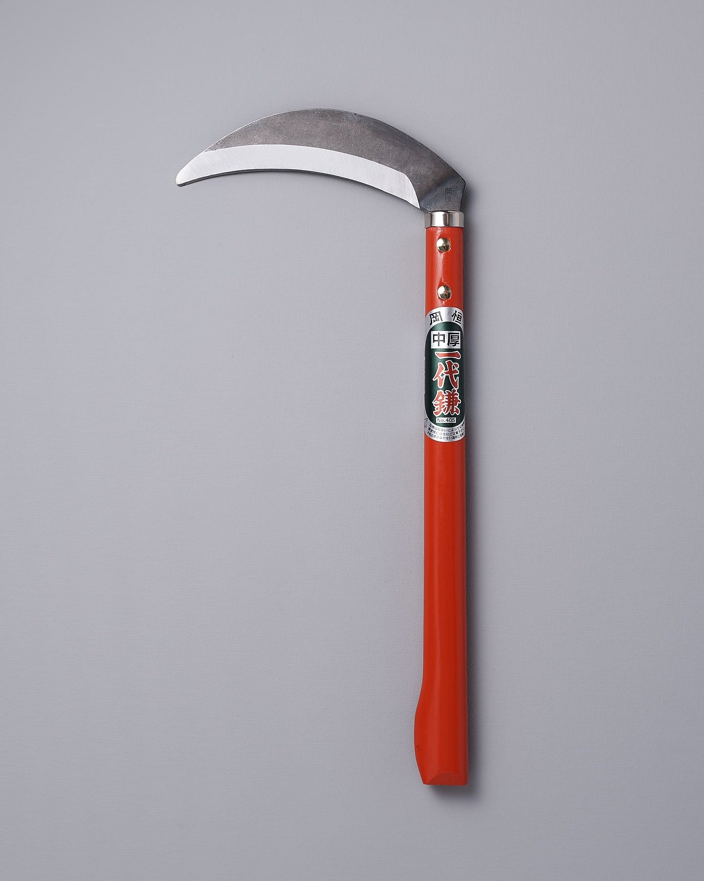 An Okatsune gardening sickle on a gray background.