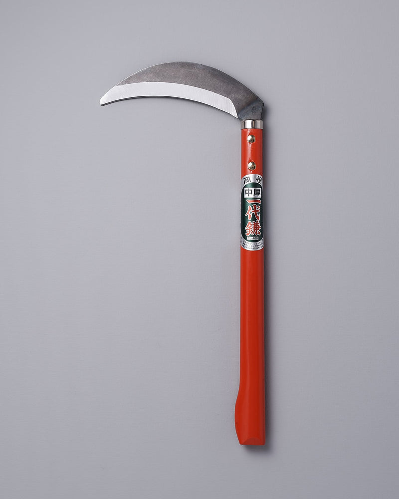 An Okatsune gardening sickle on a gray background.