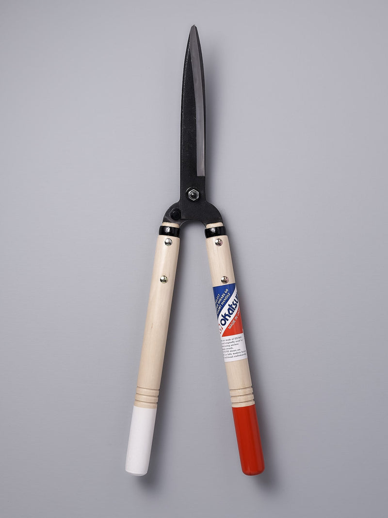 A pair of Okatsune Japanese Hedge Shears №217 – Short Handled with red and white handles.