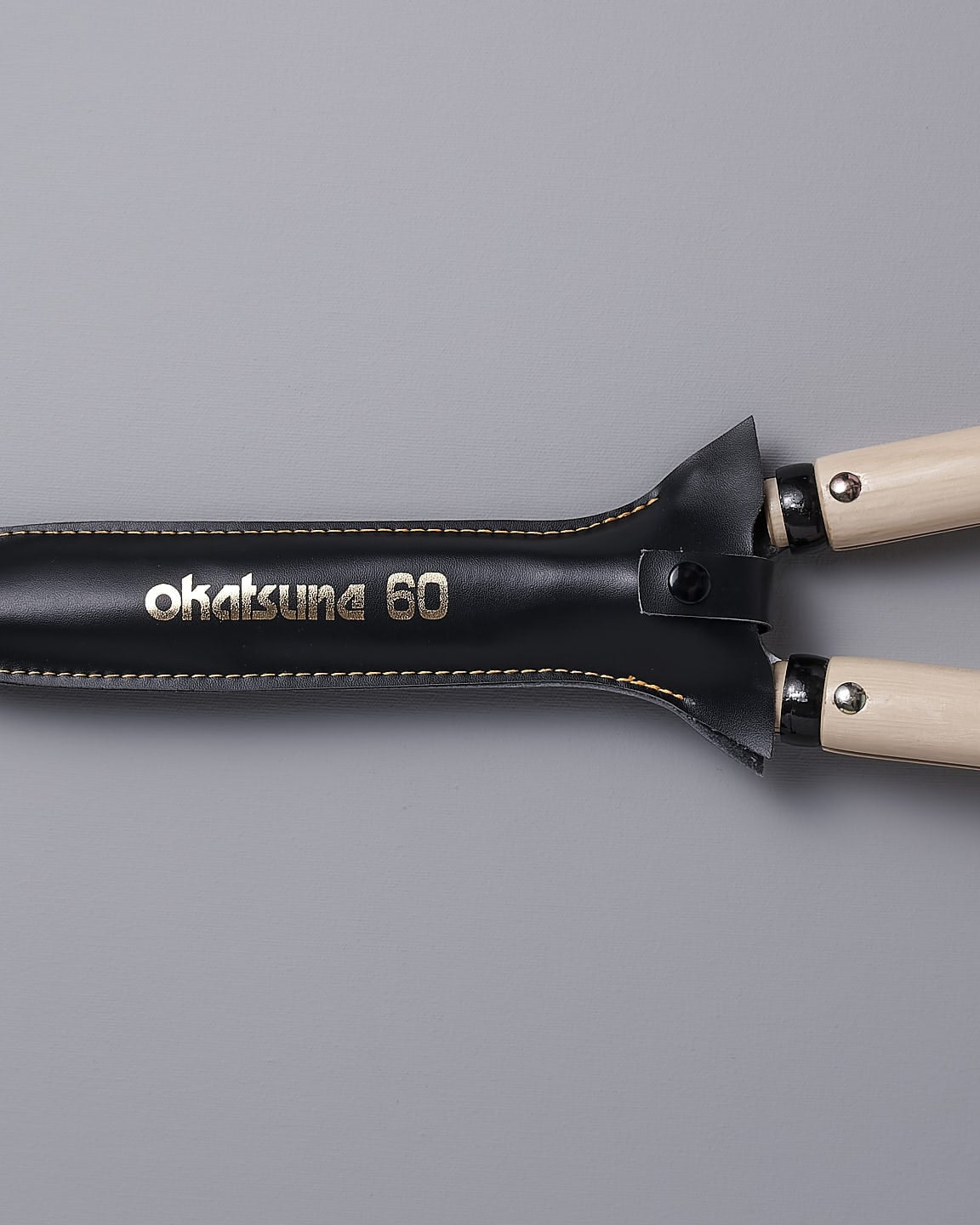 A pair of Okatsune Japanese Hedge Shears №217 – Short Handled with red and white handles.
