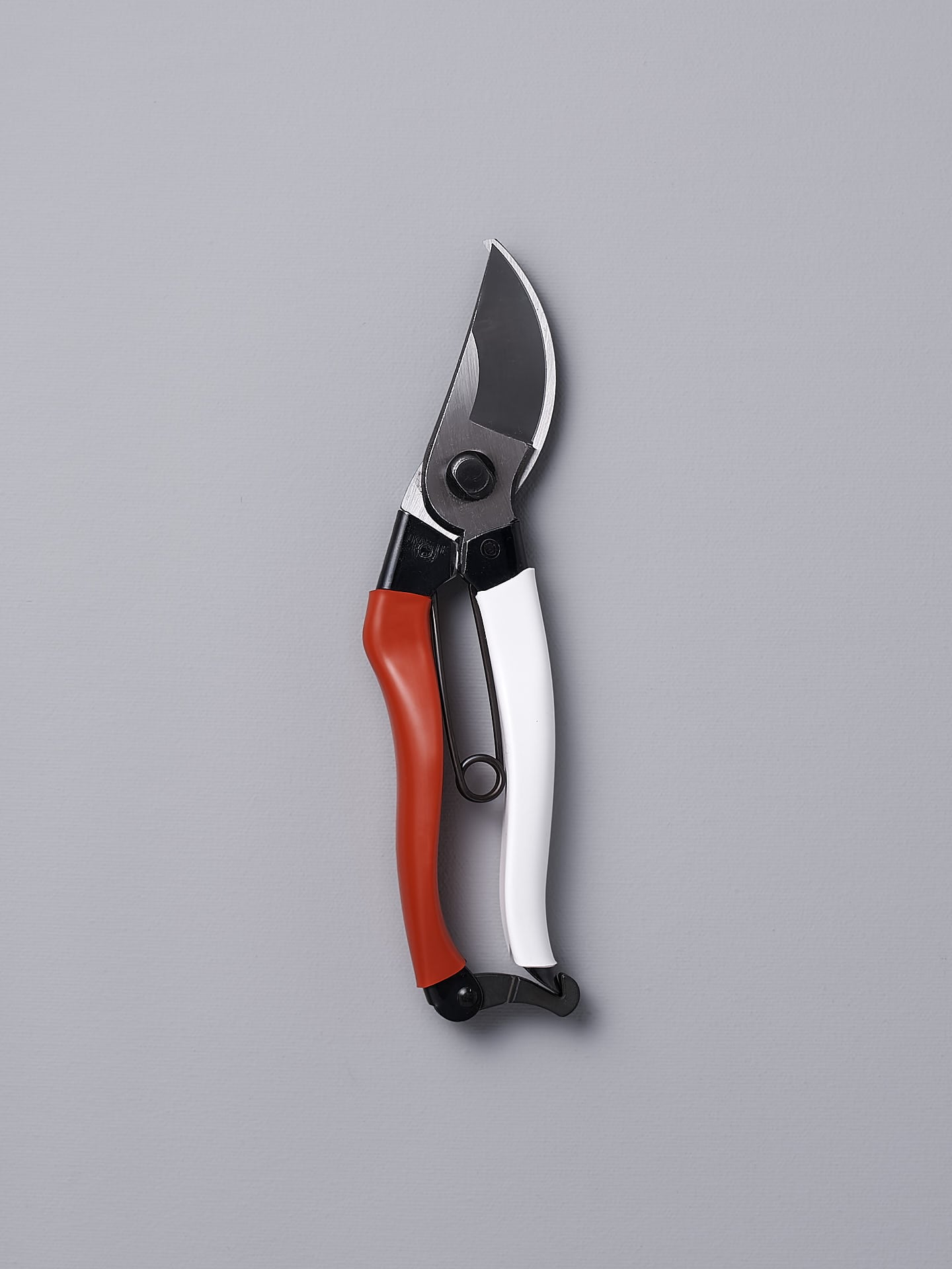 An Okatsune Japanese Secateurs №103 on a gray background.