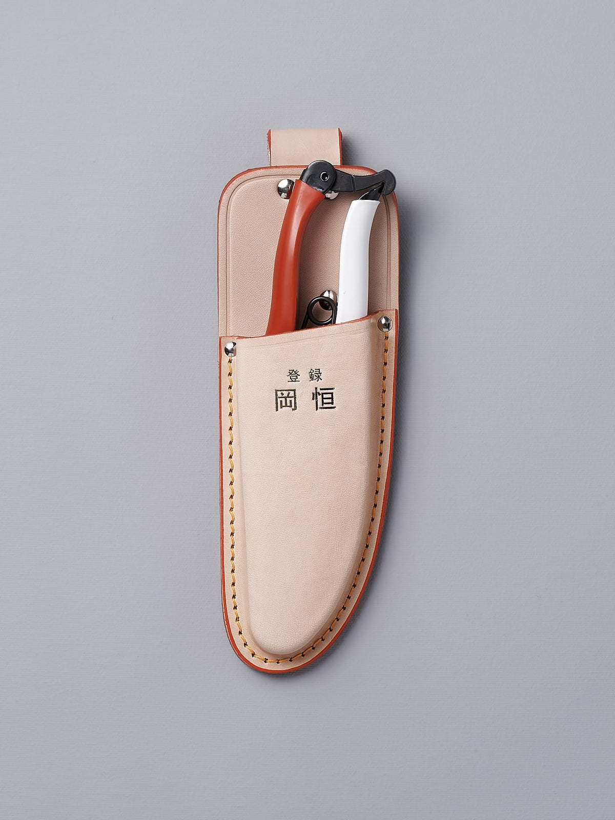 An Okatsune leather case with a pair of Japanese Secateurs №103 in it.