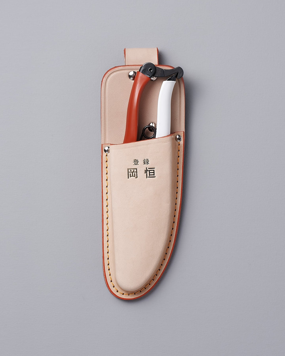 An Okatsune leather case with a pair of Japanese Secateurs №103 in it.