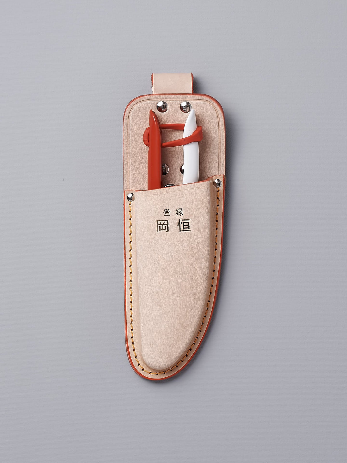 A leather pouch with a pair of Okatsune Japanese Snips №304 and a pair of Okatsune Japanese Snips №304.