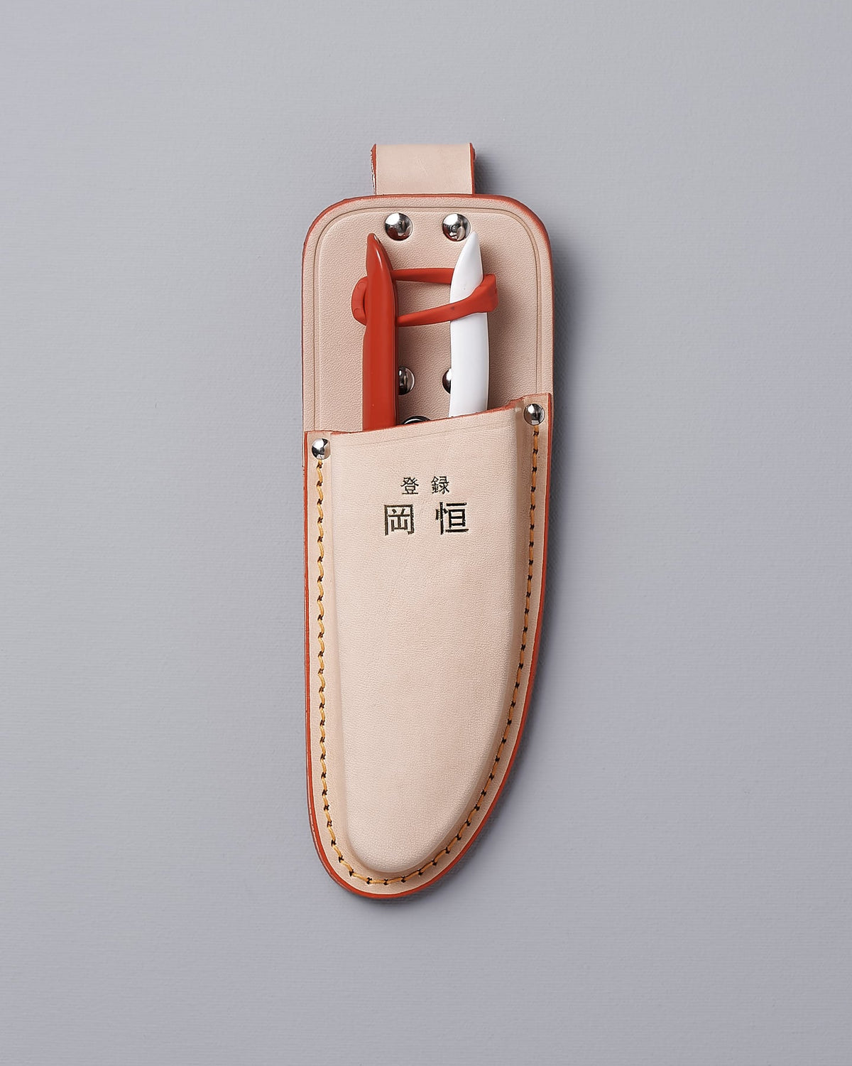 A leather pouch with a pair of Okatsune Japanese Snips №304 and a pair of Okatsune Japanese Snips №304.