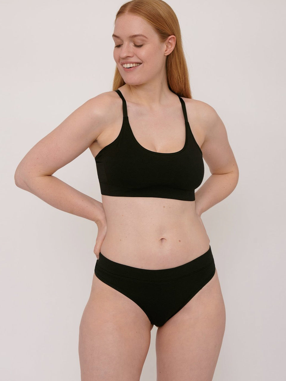A woman wearing an Organic Basics Basic Bra ⋅ organic cotton - Black bikini top.