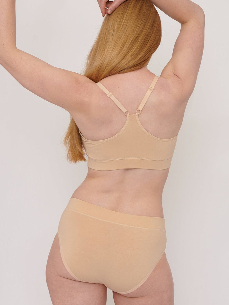 The back view of a woman wearing the Basic Bra ⋅ organic cotton – Oak by Organic Basics.