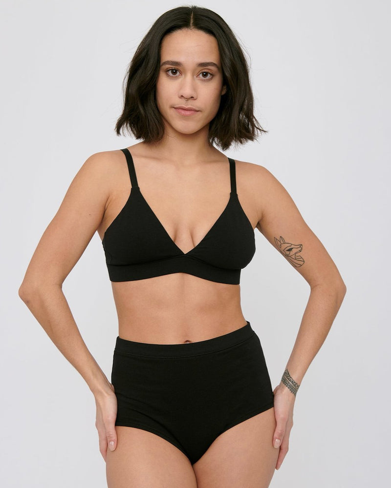 A woman wearing Organic Basics' Super High-Rise Briefs ⋅ organic cotton – (2-pack) – Black bikini top.