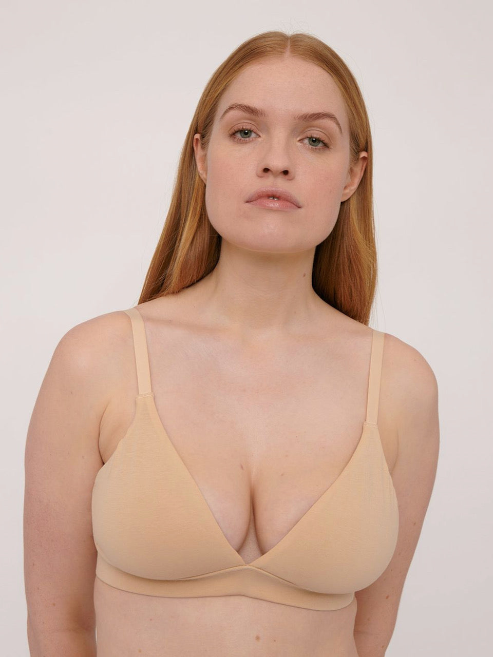 A woman in a tan bikini is posing for a photo wearing the Triangle Bra ⋅ organic cotton – Oak by Organic Basics.