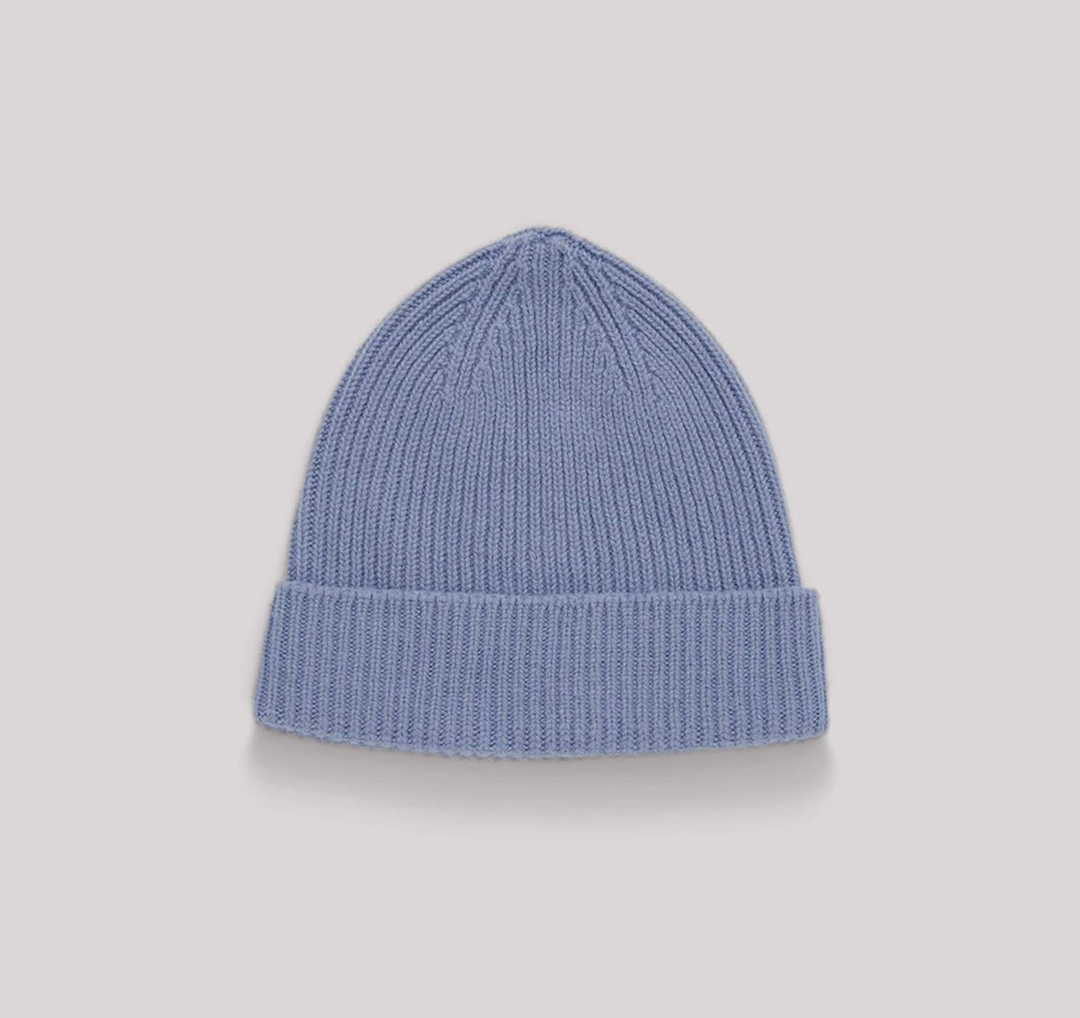 An Organic Basics Recycled Wool Beanie– Light Blue on a grey background.