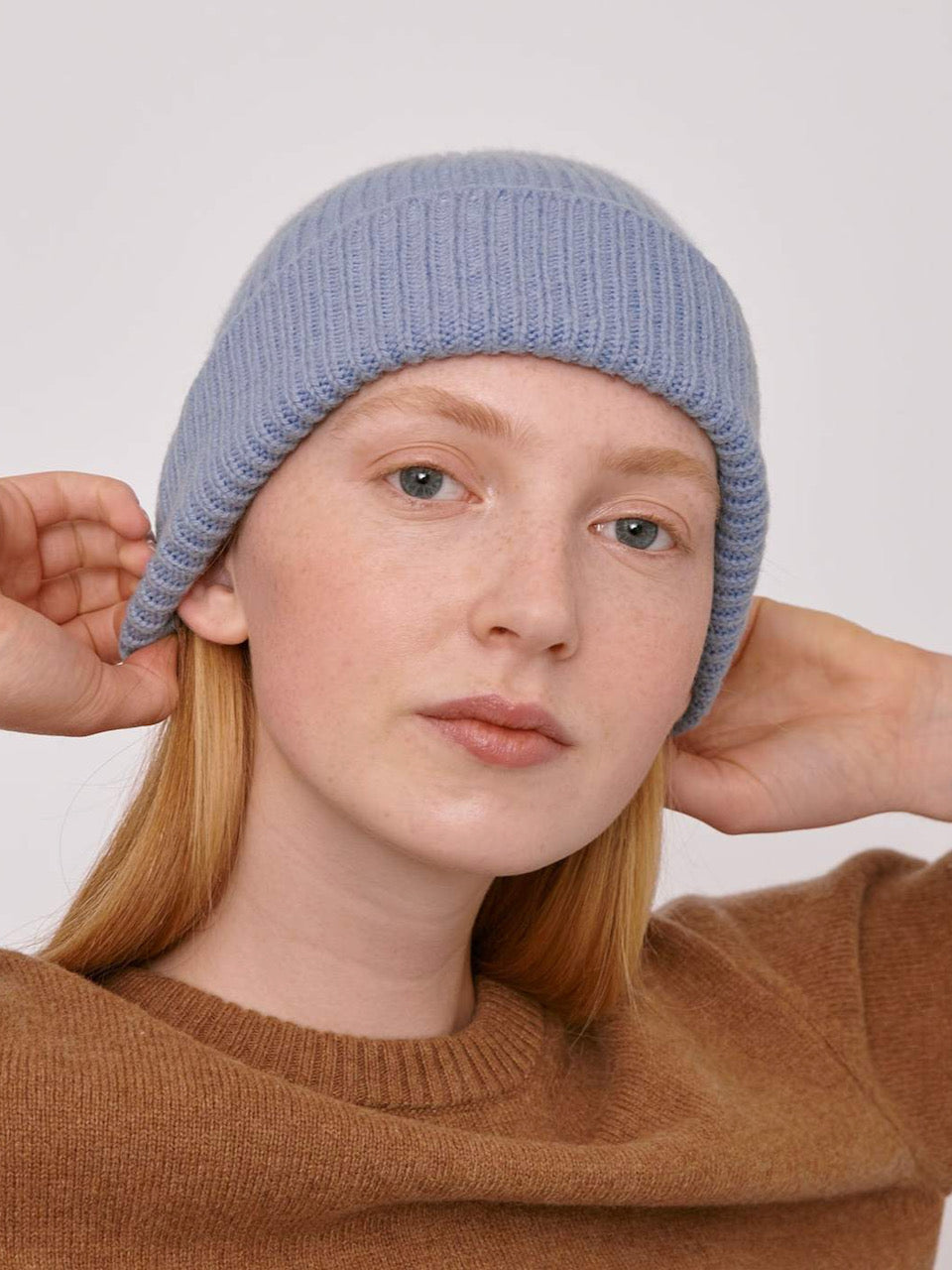 A woman wearing an Organic Basics Recycled Wool Beanie– Light Blue.