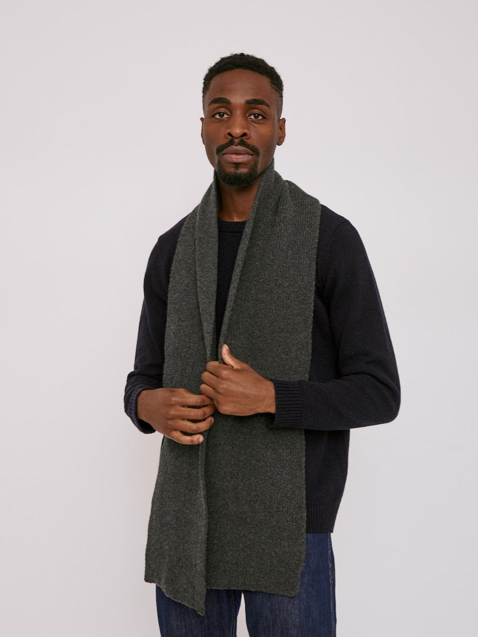 A man wearing a Organic Basics Recycled Wool Scarf – Charcoal Melange.