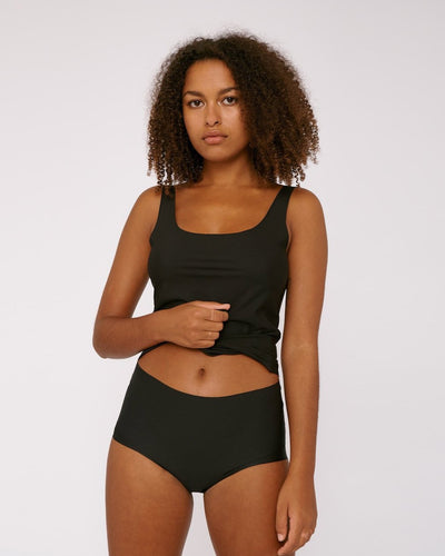 A woman wearing Organic Basics' Invisible Cheeky High-Rise Briefs (2-pack) in black.