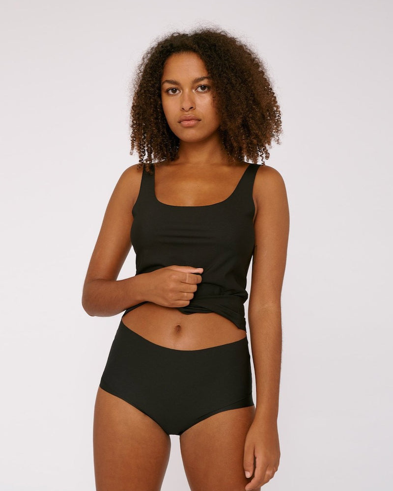 A woman wearing Organic Basics' Invisible Cheeky High-Rise Briefs (2-pack) in black.
