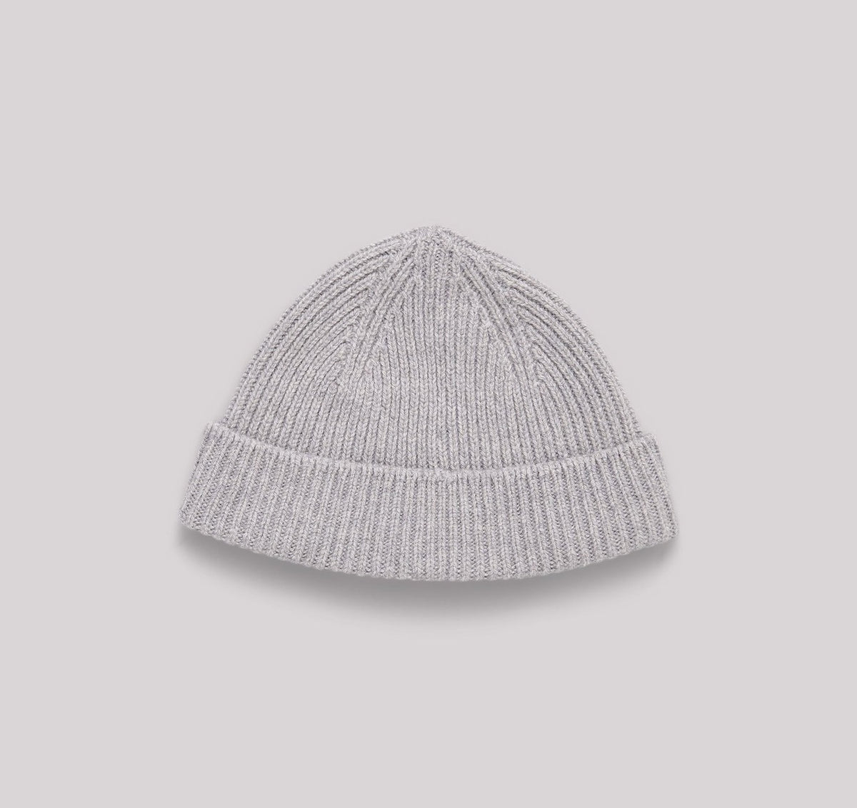 An Organic Basics Recycled Cashmere Beanie – Grey on a grey background.