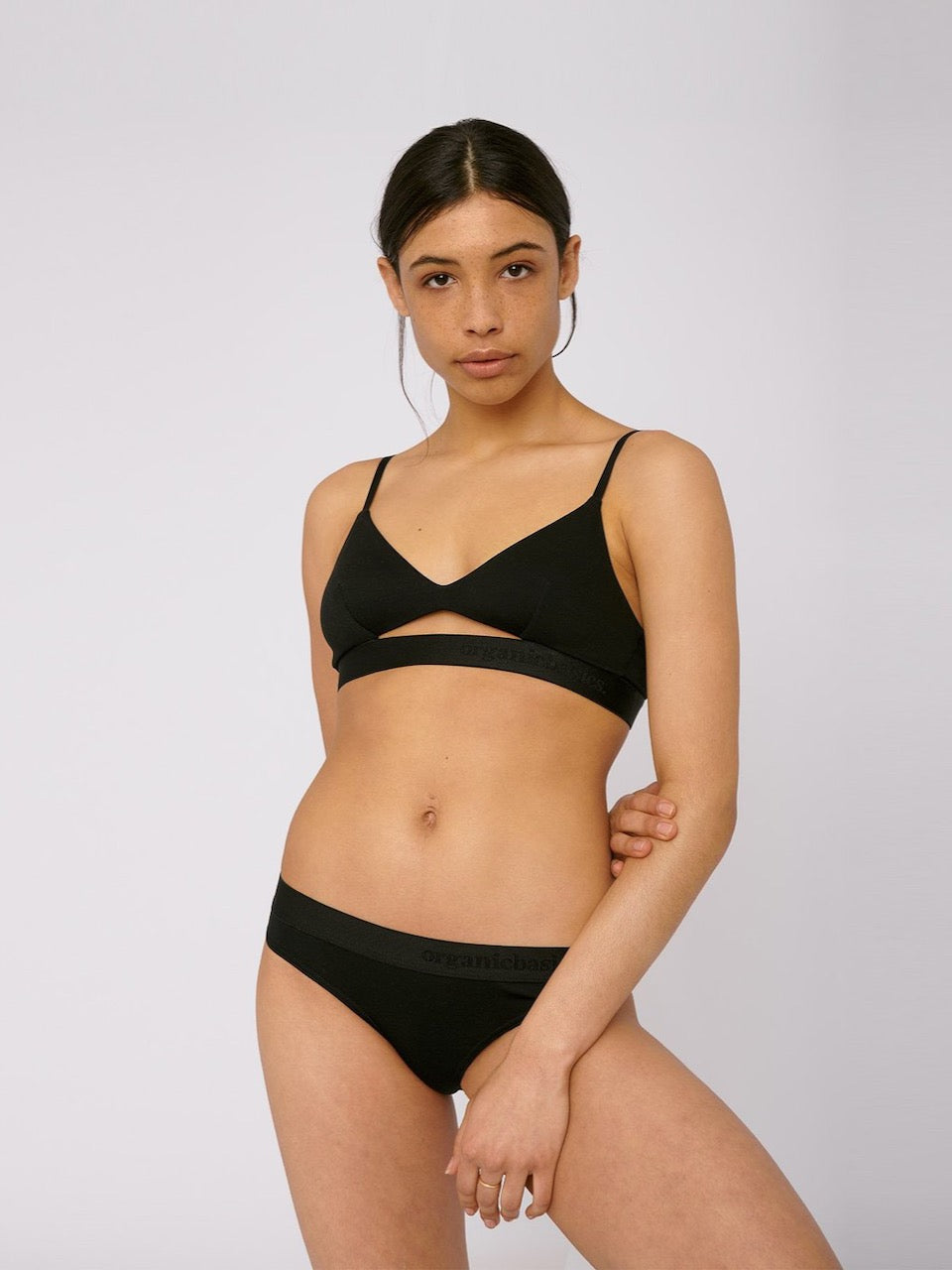 A woman wearing Organic Basics TENCEL™ Lite Briefs (2-pack) – Black bikini top and panties.