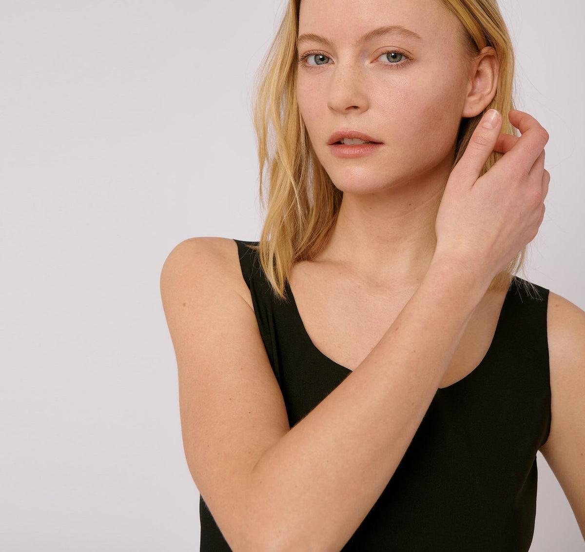 A woman wearing an Invisible Tank Top - Black from Organic Basics.