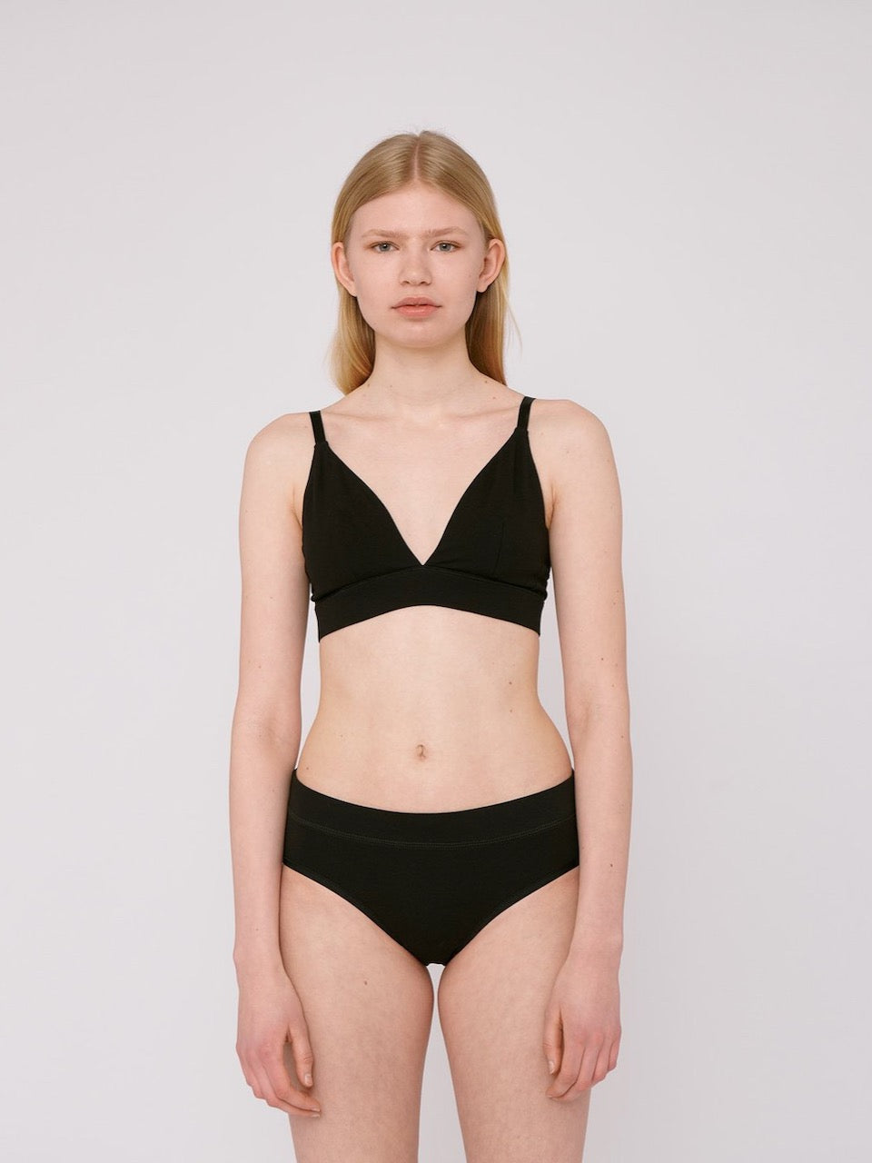 The model is wearing a black Bikini Briefs ⋅ organic cotton (2-pack) – Black by Organic Basics top.