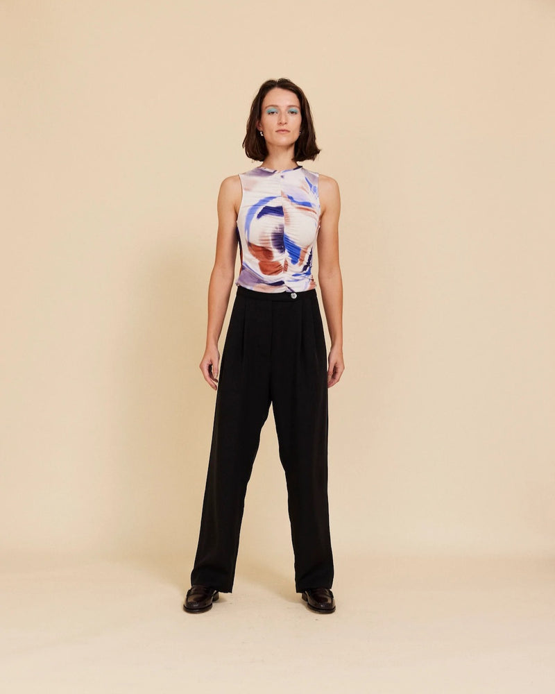 A woman wearing OVNA OVICH's Me Time Trouser – Onyx and a black top.