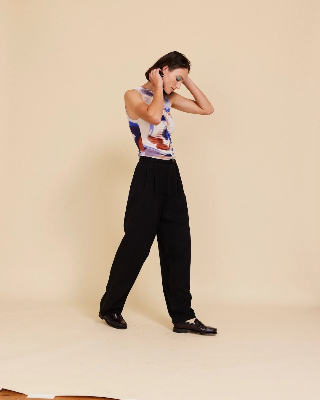 A woman wearing Me Time Trouser - Onyx pants and an OVNA OVICH top.