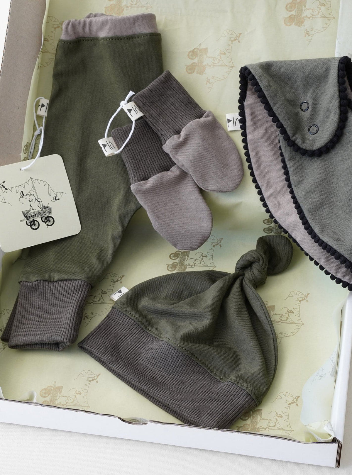 A Peppin Baby Gift Box – Forest containing a baby&#39;s hat, gloves and mittens.