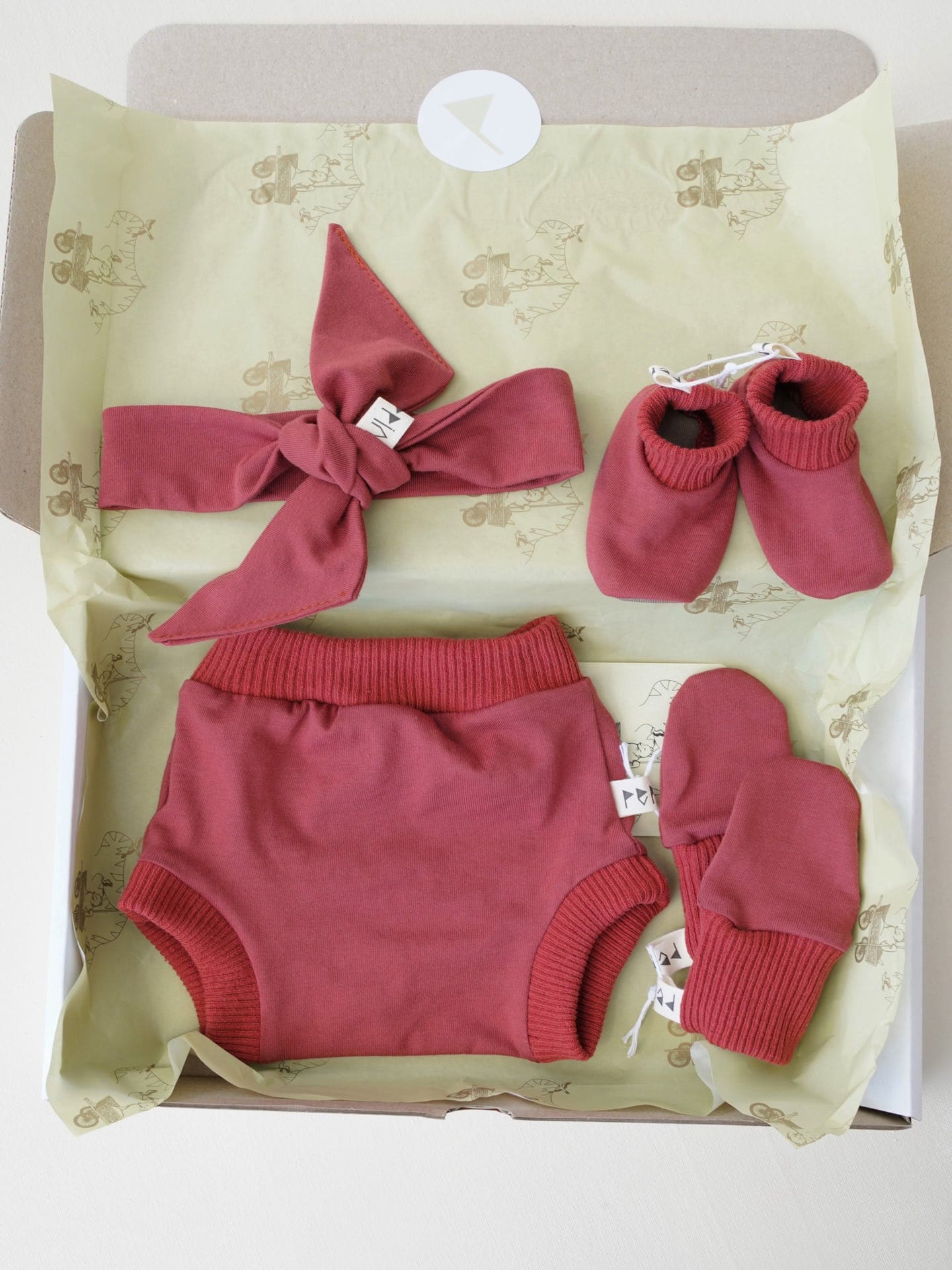A Baby Gift Box - Brick by Peppin containing a baby's clothes and shoes.