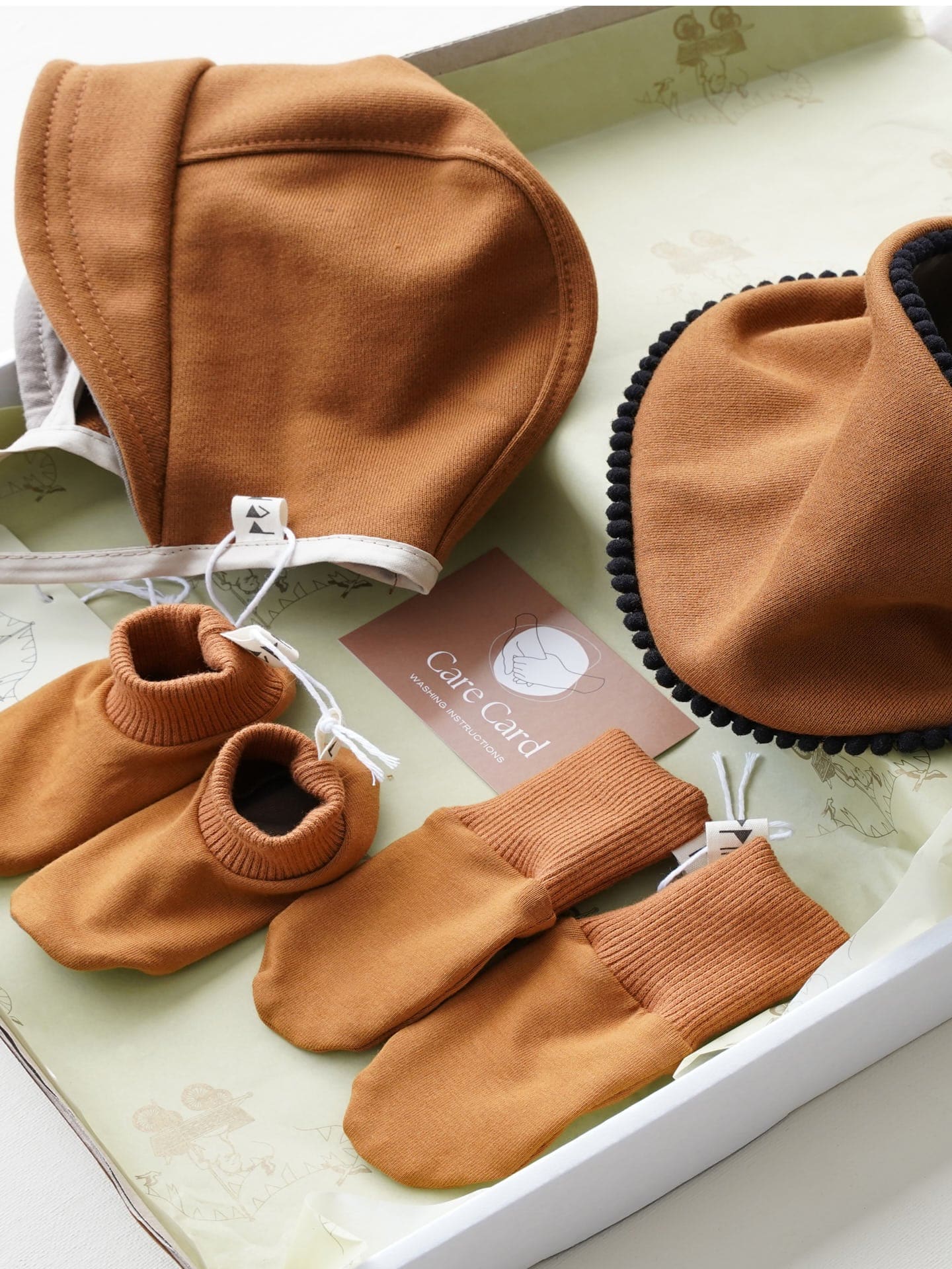A Baby Gift Box - Copper, Peppin hat, mittens and booties are in a box.