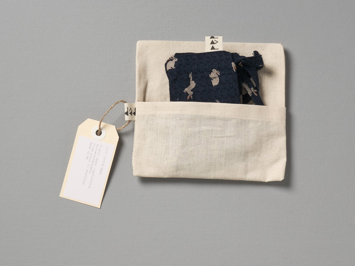 A pair of Kids Face Mask - Japanese Print by Peppin in a bag with a tag on it.