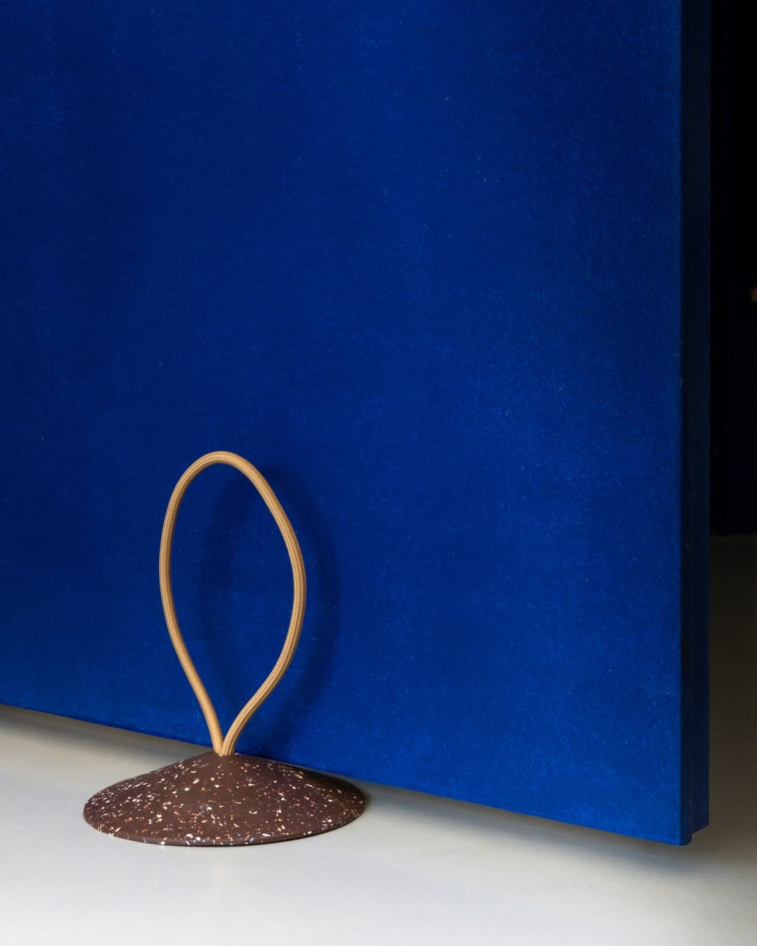 A blue wall with a Pidät STOP – Doorstop in front of it.