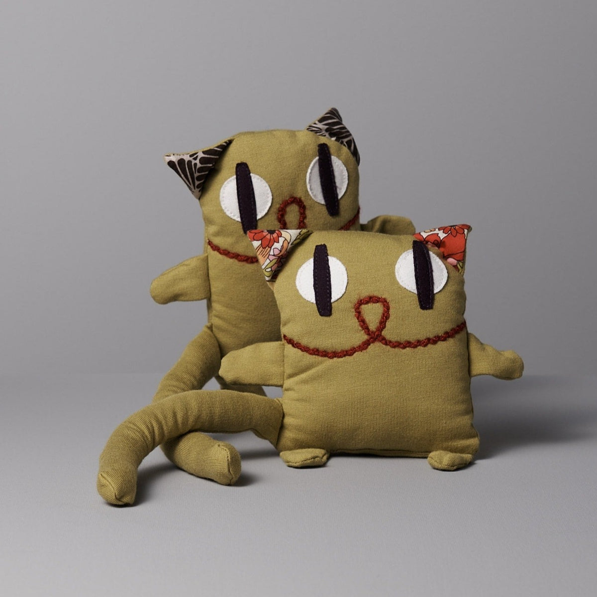 A pair of Raplapla stuffed cats with eyes on them: Serge the Cat.