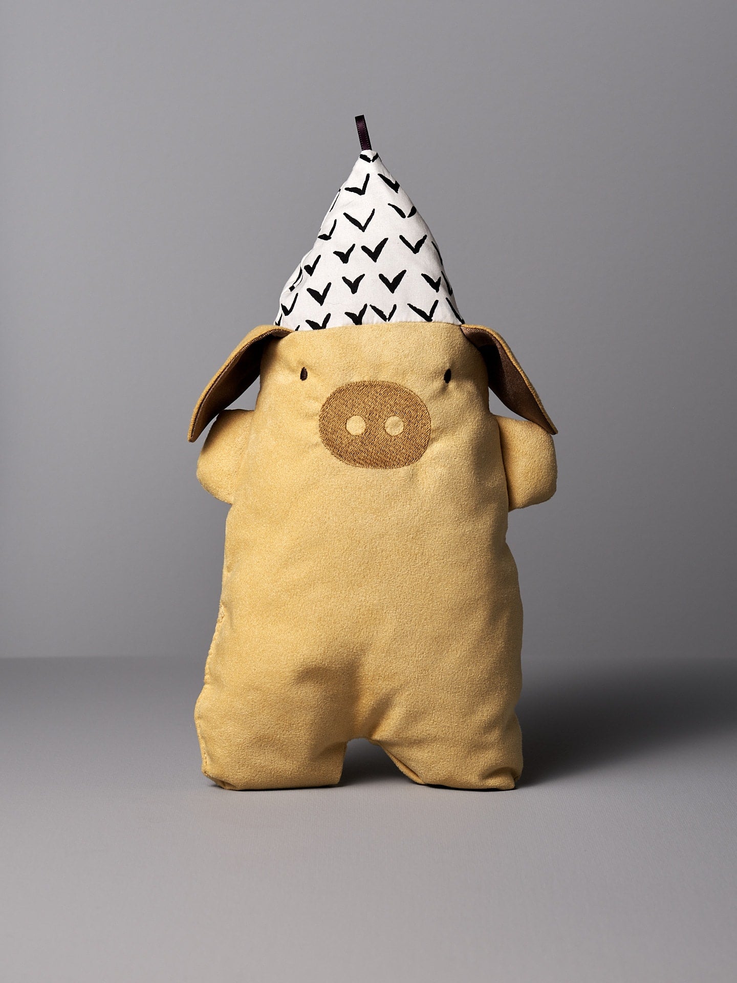 A Yali le Cochon stuffed pig wearing a party hat from Raplapla.
