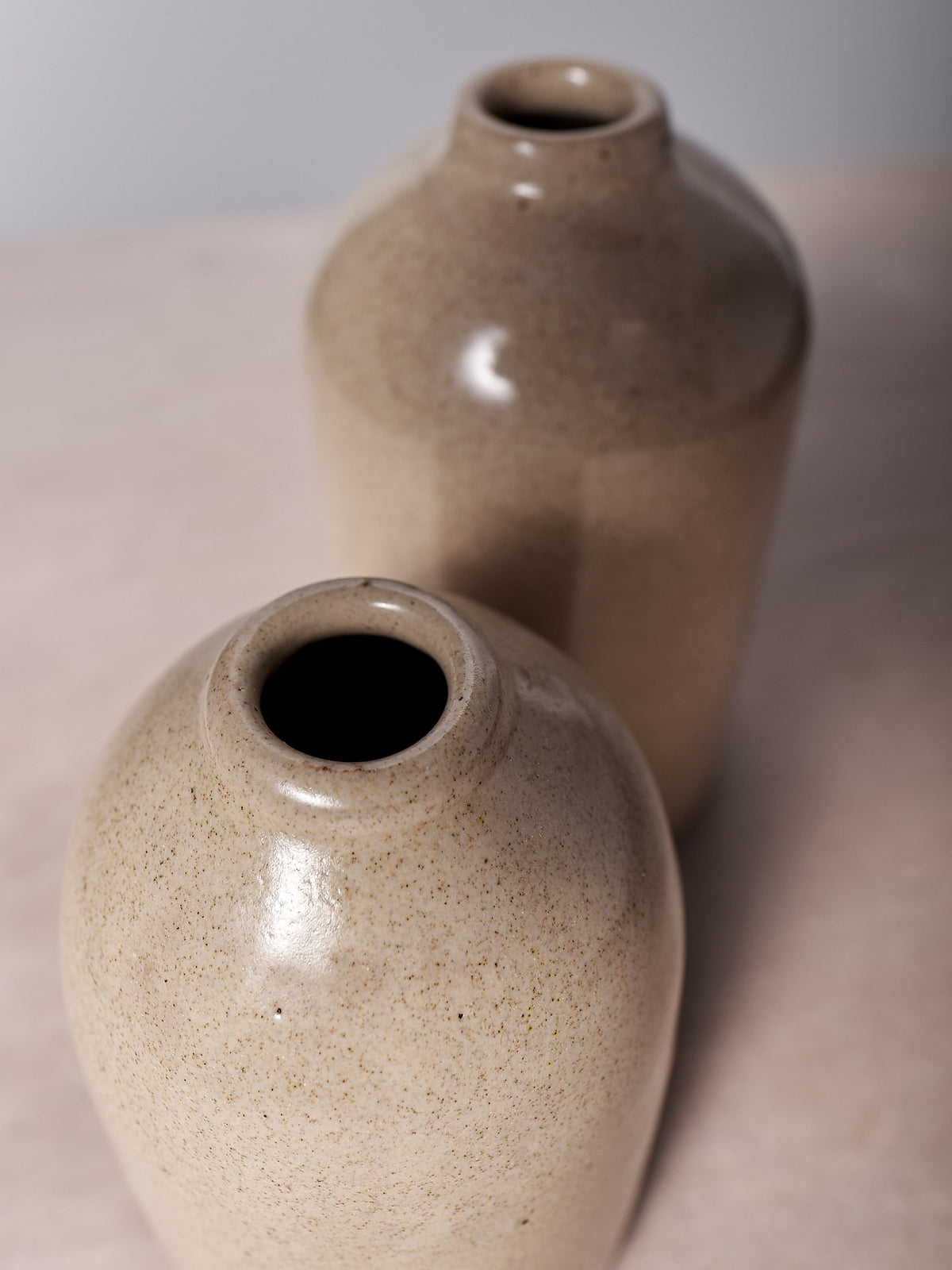 Two Richard Beauchamp Medium Bud Vase – Sand on a table.